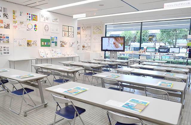 説明会会場の様子と参加者にお渡ししている卒業生がデザインした「POCHI」「ころまるさん」シリーズのグッズ